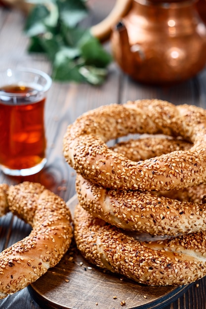 Foto traditionelles weißbrot mit sesam zum frühstück, ein glas armudu mit rotem tee auf einem holztisch