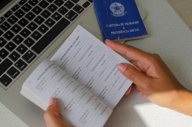 Traducción de la tarjeta de trabajo brasileña 'Ministerio de Trabajo de la República Federativa de Brasil' Concepto de FGTS desempleo PIS salario jubilación empleado y economía brasileña Libro de trabajo de mano