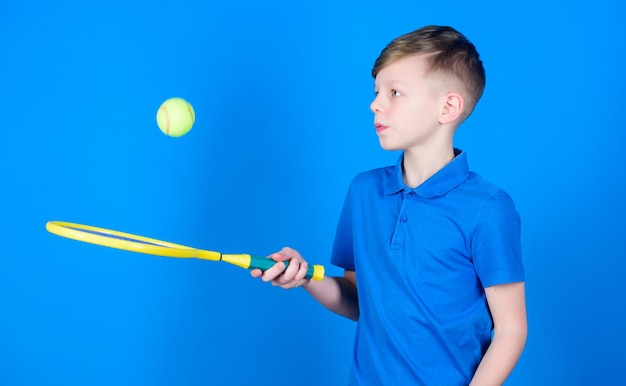 Träumen von Sportkarriere Athlet Kid Tennisschläger auf blauem Hintergrund Tennissport und Unterhaltung Junge Kinder spielen Tennis Übende Tennisfähigkeiten Kerl mit Schläger genießen Spiel Zukünftiger Champion