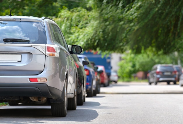 Tráfego da cidade com carros estacionados em fila do lado da rua. Conceito de estacionamento de veículos.