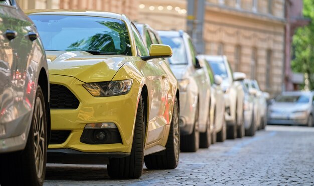 Tráfego da cidade com carros estacionados em fila do lado da rua.