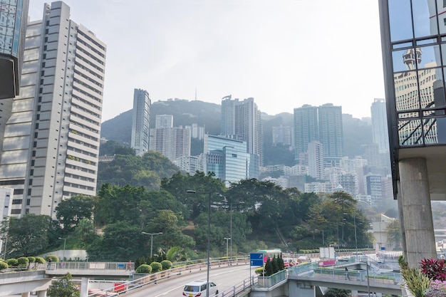 Tráfego rodoviário e arranha-céus da ilha de Hong Kong. Pessoas no fundo