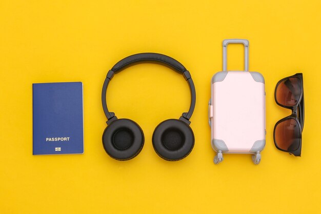 Trafel Flat lay. Auriculares estéreo y accesorios de viaje sobre un fondo amarillo. Vista superior