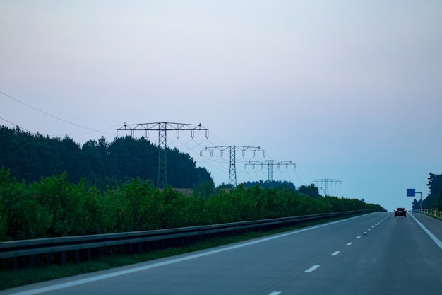 Tráfico de la carretera al atardecer con coches y camiones.