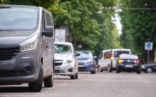 Tráfico de la ciudad con autos estacionados en línea en el lado de la calle