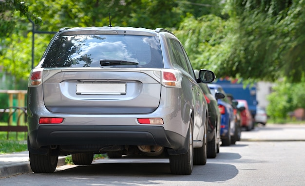 Tráfico de la ciudad con coches aparcados en fila al lado de la calle. Concepto de estacionamiento de vehículos.