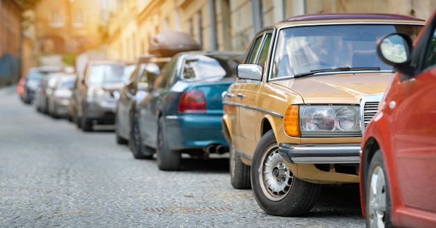 Tráfico de la ciudad con coches aparcados en línea al lado de la calle