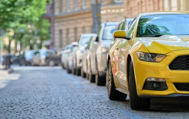 Tráfico de la ciudad con coches aparcados en línea al lado de la calle