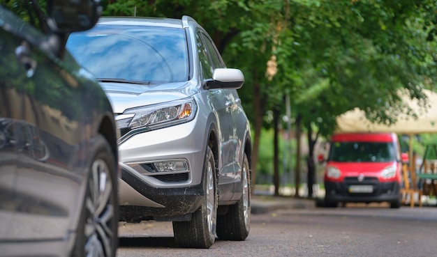 Tráfico de la ciudad con coches aparcados en línea al lado de la calle