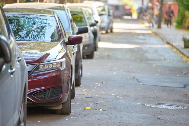 Tráfico de la ciudad con muchos coches aparcados en fila al lado de la calle