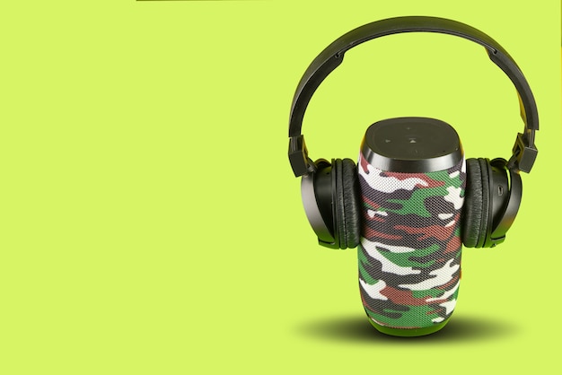 Tragbarer Lautsprecher und Headset auf grünem Hintergrund