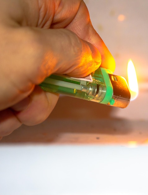 Tragbares brennendes Gasfeuerzeug auf weißem Hintergrund Gerät zum Zünden einer Flamme Gasfeuerzeug aus Kunststoff