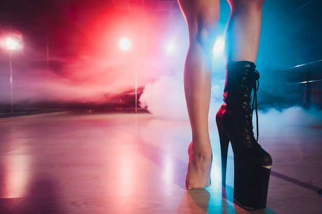 Tragen Sie einen hohen Stiefel auf Plattform und Ferse. Striptease-Tänzerin bewegt sich auf der Bühne im Strip-Nachtclub.