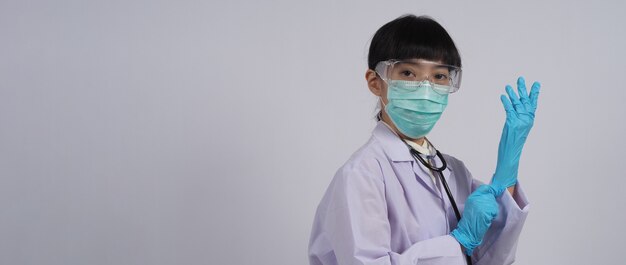 Tragen von Handschuhen Asiatischer Arzt trägt blauen Nitril-Gummihandschuh Doc mit einer Maske, die Handschuhe anzieht