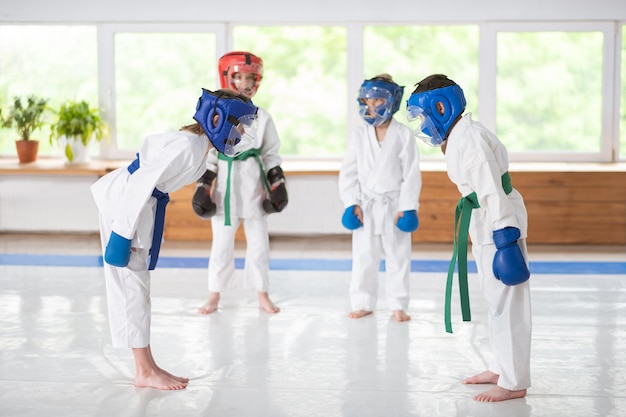 Tragen von Schutzhelmen. Jungen und Mädchen tragen Schutzhelme und Boxhandschuhe beim gemeinsamen Üben