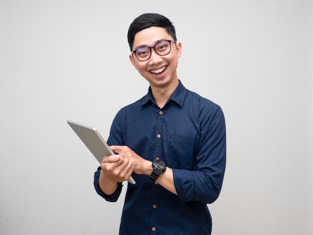 Tragende Brille des asiatischen Geschäftsmannes unter Verwendung des netten Lächelns der Tablette lokalisiert