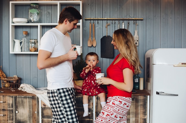 Tragende Pyjamas der glücklichen Familie Weihnachts, die zusammen mit kleiner Tochter kochen.