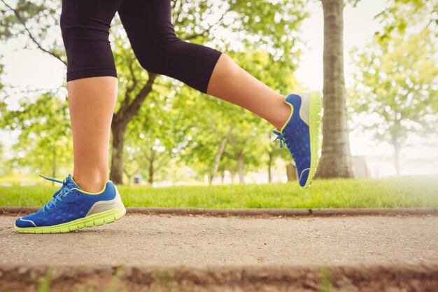 Tragende Sportschuhe der Frau, die im Park rütteln