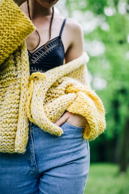 Tragende Strickjacke der jungen Frau und Aufstellung des Parks