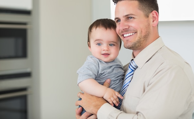 Tragendes Baby des glücklichen Geschäftsmannes