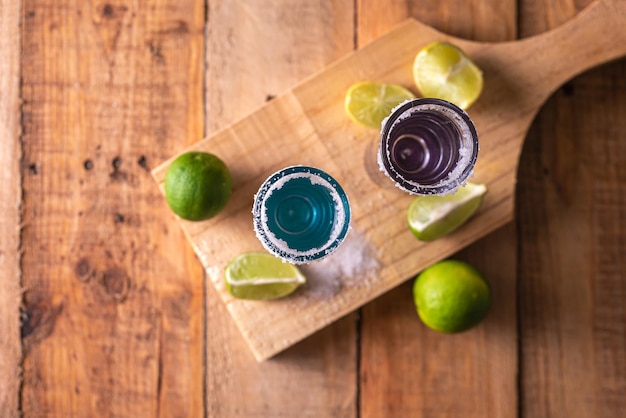 Tragos de tequila con sal y lima en una mesa de bar