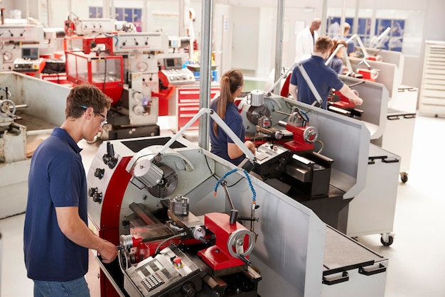 Foto trainee-ingenieure, die geräte in einer kleinen fabrik bedienen