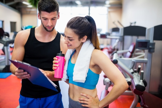 Trainer, der der Frau Trainingsregime erklärt