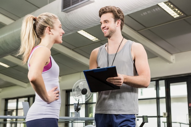 Trainer, der mit Frau nach einem Training spricht