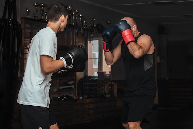 Trainer und Boxer-Teenager beim Training im Fitnessstudio