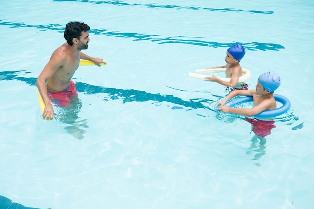 Trainer und Schüler interagieren im Schwimmbad des Freizeitzentrums miteinander