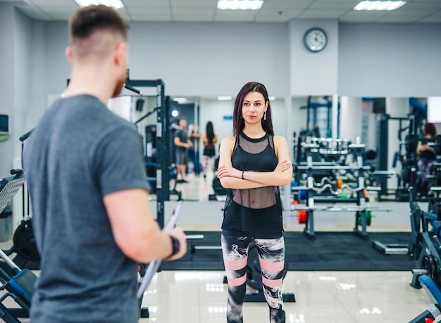 Trainerin und Klientin diskutieren über ihre Fortschritte bei der Gymnastikübung Persönlicher Fitnesstrainer