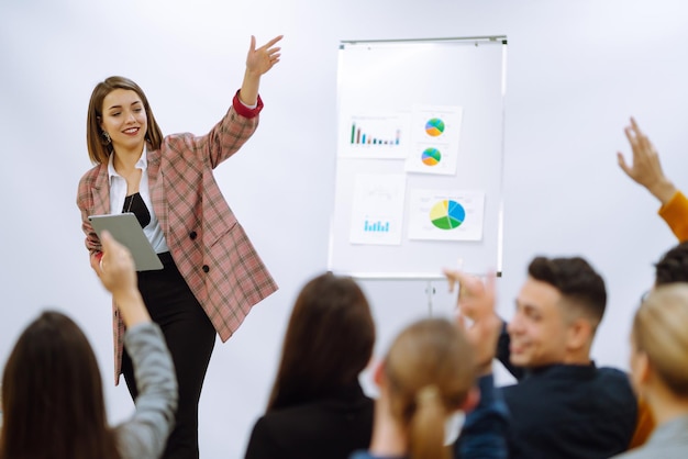 Foto trainersprecherin der jungen frau, die flipchart-präsentationssprecher-führungstraining gibt