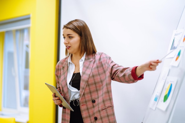 Trainersprecherin der jungen Frau, die Flipchart-Präsentationssprecher-Führungstraining gibt