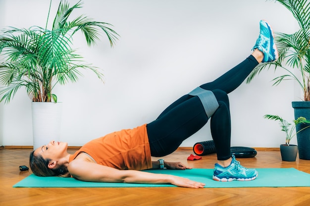 Trainieren zu Hause Frau mit elastischem Band für Krafttraining