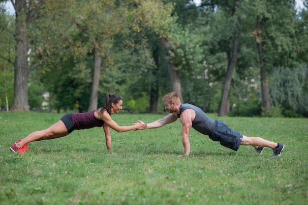 Training der jungen Frau mit ihrem persönlichen Trainer im Park