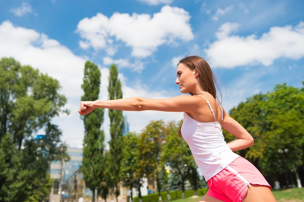 Training einer Frau, die sonnig im Freien auf Sport und Fitness des blauen Himmels schlägt