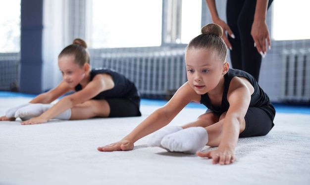 Foto training in der gymnastikklasse eine gruppe von kindern unter anleitung eines trainers führt übungen durch gymnastikkonzept mischmedien