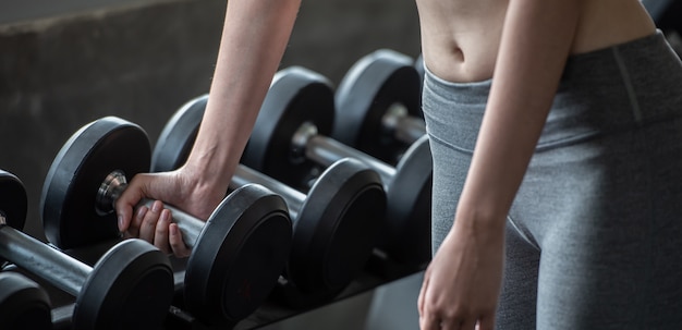 Trainingsfrau mit Gewichtheben für schlanken Körper und Gebäude der dünnen Form des Körpers.