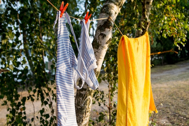 Traje de baño de mujer y toalla amarilla secar al sol.