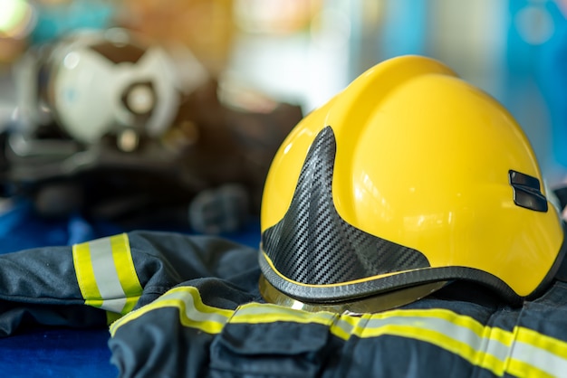 Foto traje de bombero y casco amarillo, ropa de protección contra incendios y equipo para salvar vidas.