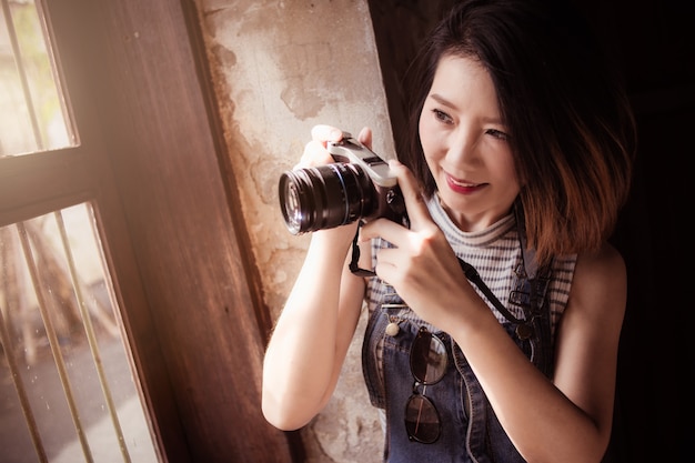 traje casual hermosa mujer asiática con cámara y cosas de viaje con fondo