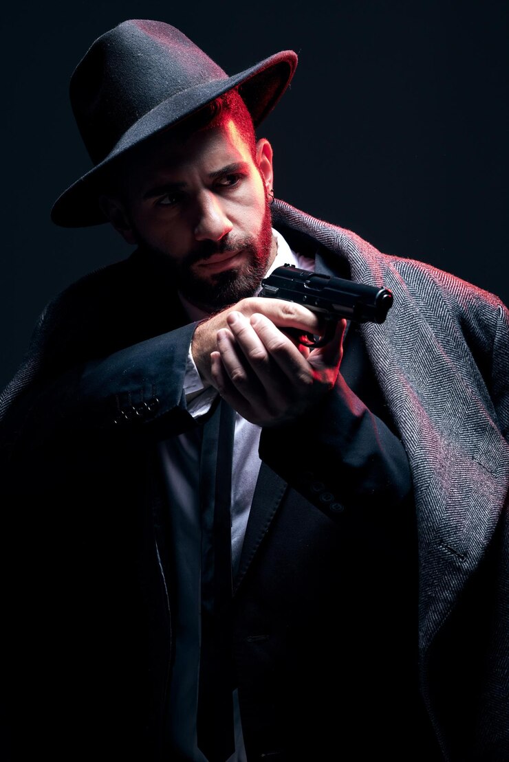 Foto traje de guarda-costas ou arma de tiro no fundo do estúdio em espião secreto escuro, liderança da máfia isolada ou senhor do crime, modelo de segurança, homem e gângster mirando arma em roupas formais ou de moda estética