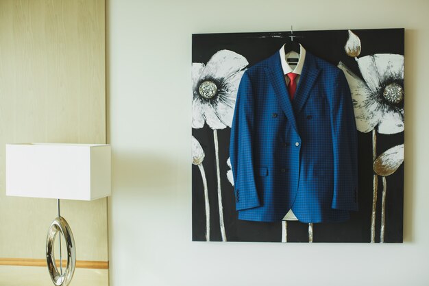 Foto traje de hombre azul colgado de un cuadro