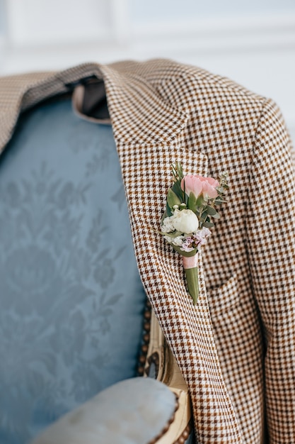 Traje de novio con flor en el ojal de boda