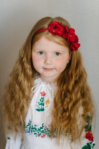 Traje ou vestido tradicional étnico nacional Retrato de uma menina vestida com um vestido bordado folclórico ucraniano Uma criança com uma coroa de papoulas na cabeça Menina ucraniana Tradições aduaneiras ucranianas