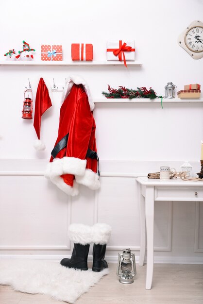 Traje de Papá Noel colgado en la sala blanca