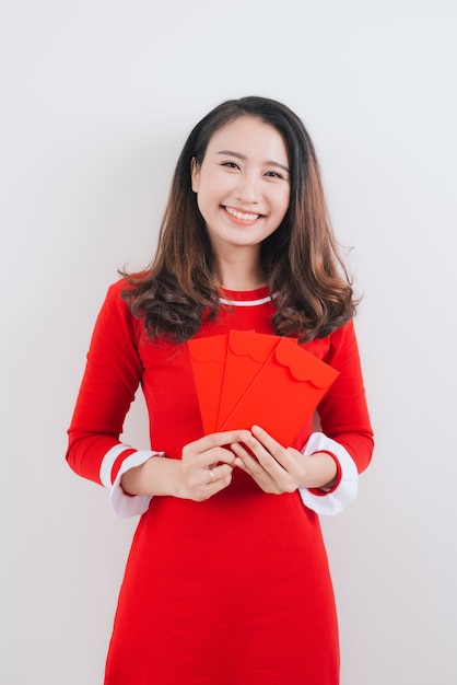 Traje tradicional do festival de mulher vietnamita Ao Dai, segurando os bolsos de dinheiro vermelho.