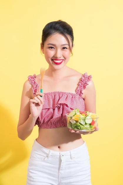 Traje de verano de mujer hermosa asiática posando con plato de ensalada fresca