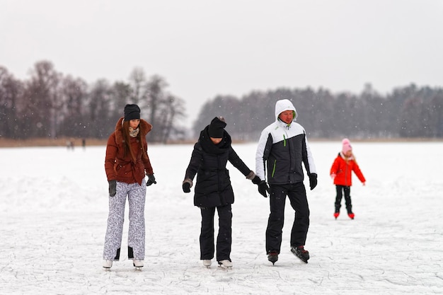 Trakai, Lituânia - 17 de janeiro de 2016: Amigos patinação no gelo na pista em Trakai coberto de neve. A patinação envolve qualquer atividade que consiste em viajar no gelo usando patins. Foco seletivo