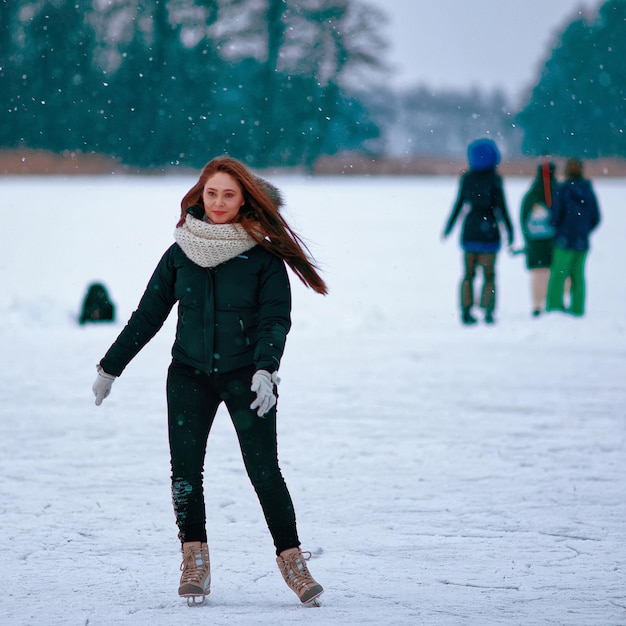 Trakai, Lituania - 17 de enero de 2016: Patines de hielo de niña en la pista de invierno cubierta de nieve en Trakai, en Lituania. Enfoque selectivo en movimiento